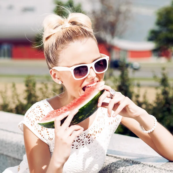Flicka i vit sommarklänning äter vattenmelon — Stockfoto