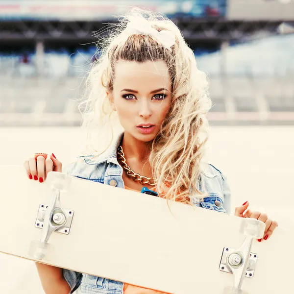 Belle jeune femme avec une planche à roulettes avec terrasse vierge — Photo