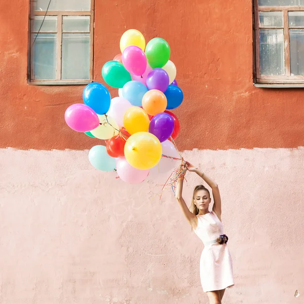 Hermosa dama en traje retro sosteniendo un montón de globos betwe —  Fotos de Stock