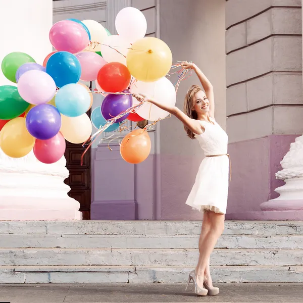 Hermosa dama en traje retro sosteniendo un montón de globos en th — Foto de Stock