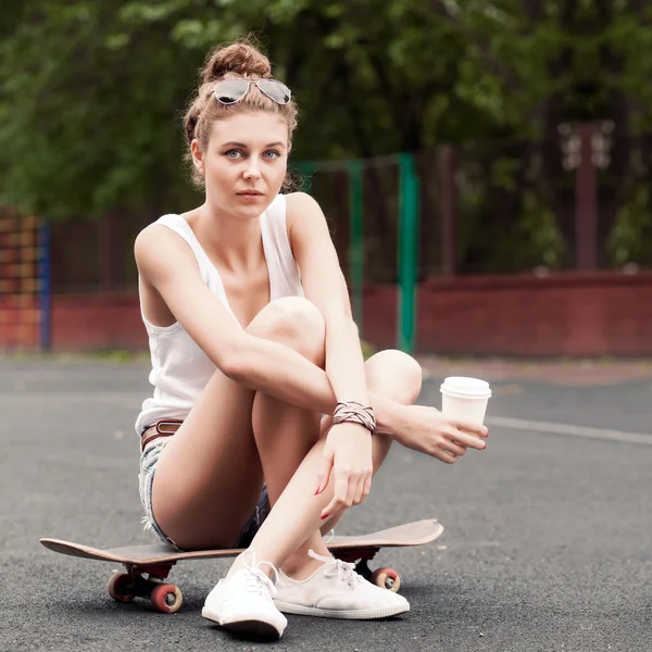 Belle dame sexy en jeans shorts avec skateboard et to-go cu — Photo