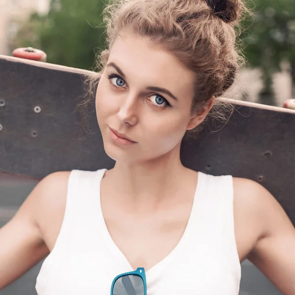 Mooie sexy dame in wit t-shirt met skateboard bij sport co — Stockfoto