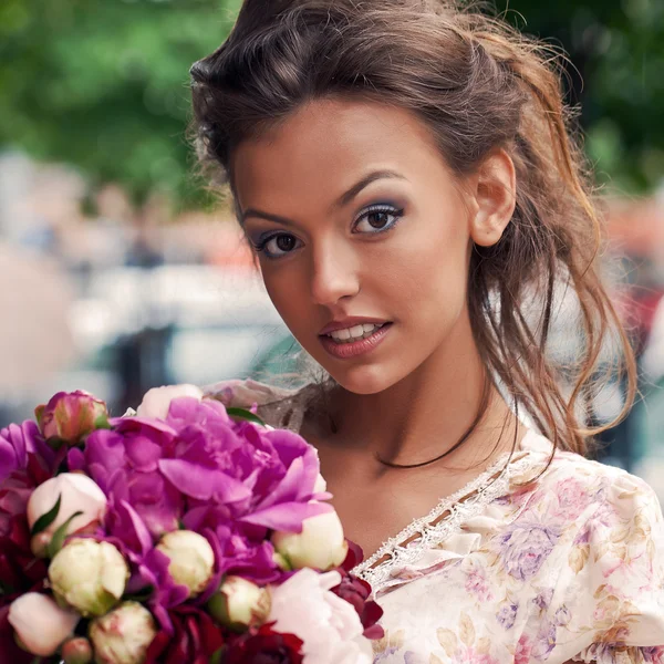 A beautiful young girl in summer dress with a bunch of flowers i — Stock Photo, Image