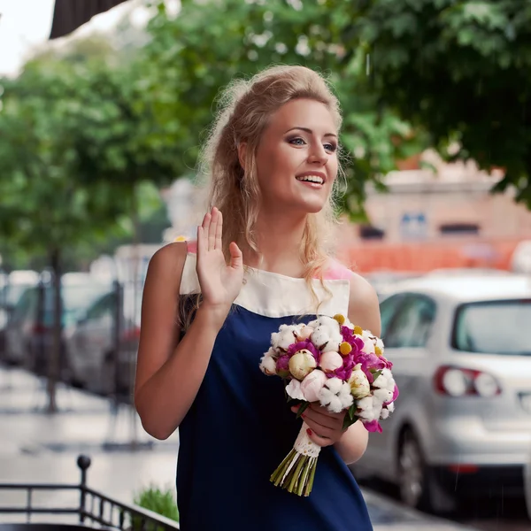 Ein schönes junges Mädchen im Sommerkleid mit einem Blumenstrauß — Stockfoto
