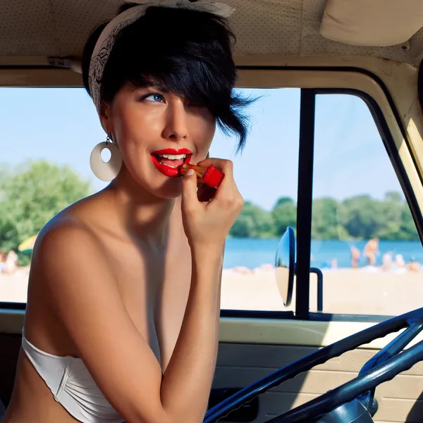 A beautiful retro-looking girl with blue eyes near the steering — Stock Photo, Image