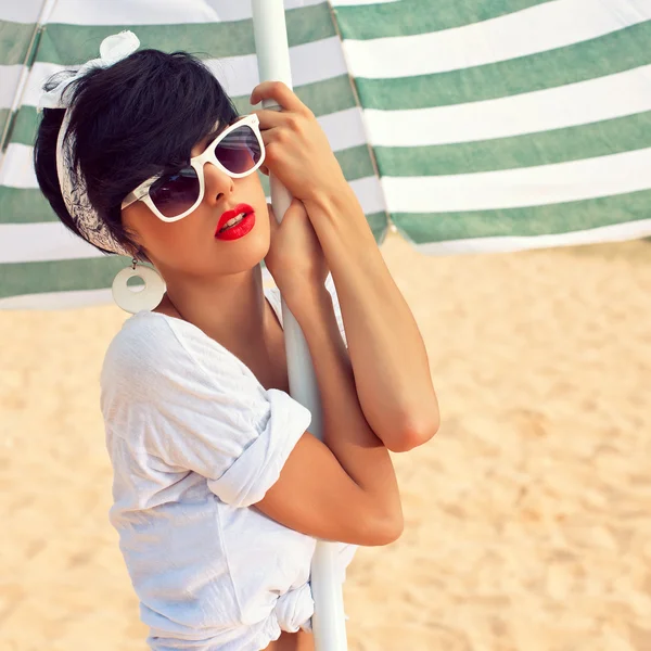 Een mooi jong meisje in retro-look met rode lippen in een witte sw — Stockfoto