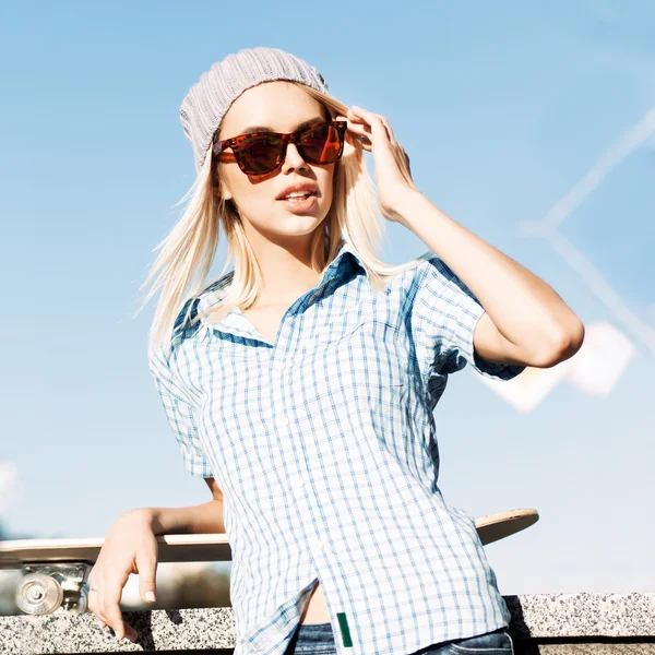 Beautiful blonde girl in beanie hat and leopard sunglasses with — Stock Photo, Image