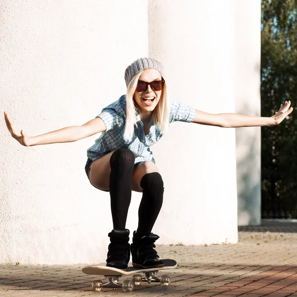 Menina loira bonita em shorts curtos com skate — Fotografia de Stock