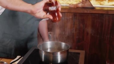 Nehirde şef bir tabak brokoli ve soslu kızarmış balık hazırlıyor.