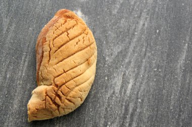 Taze, kabarık, şekerli ve Meksika peyniri ile doldurulmuş tatlı ekmeği ahşap masada, renkli peçetede sıcak kahve eşliğinde.