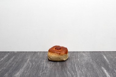 Taze, lezzetli ve taze yapılmış tahtadan bir masada, kahvaltıda sıcak kahvenin eşlik ettiği renkli bir peçeteyle yenmeye hazır tatlı bir ekmek.