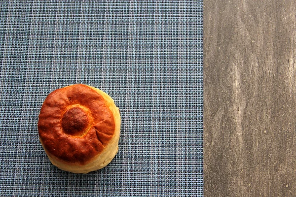 新鮮でおいしく 新しく作られた甘いビスケットパンは 朝食のためのホットコーヒーを伴う色のナプキンで木製のテーブルで食べる準備ができています — ストック写真