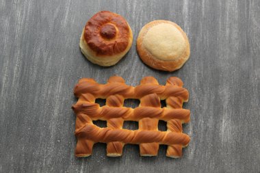 Bisküvi, kruvasan, ızgara ve tüylü solucan gibi Meksika tatlı ekmeği, taze, ahşap bir masada peçete ve sepetle taze yapılmış.