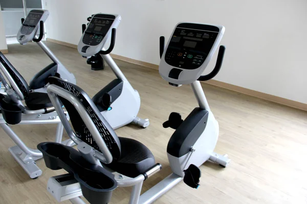 Kardiyo, tonlama bacakları, yanan kaloriler ve kilo vermek için spor salonunda duran siyah ve beyaz elektrikli düz bisiklet.