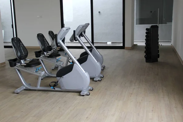 Kardiyo, tonlama bacakları, yanan kaloriler ve kilo vermek için spor salonunda duran siyah ve beyaz elektrikli düz bisiklet.