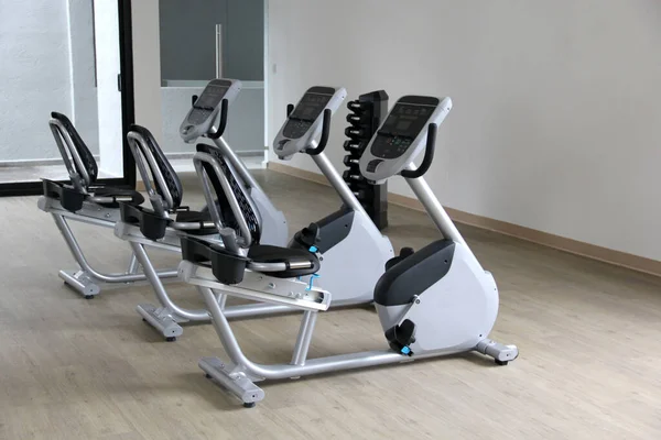 Kardiyo, tonlama bacakları, yanan kaloriler ve kilo vermek için spor salonunda duran siyah ve beyaz elektrikli düz bisiklet.