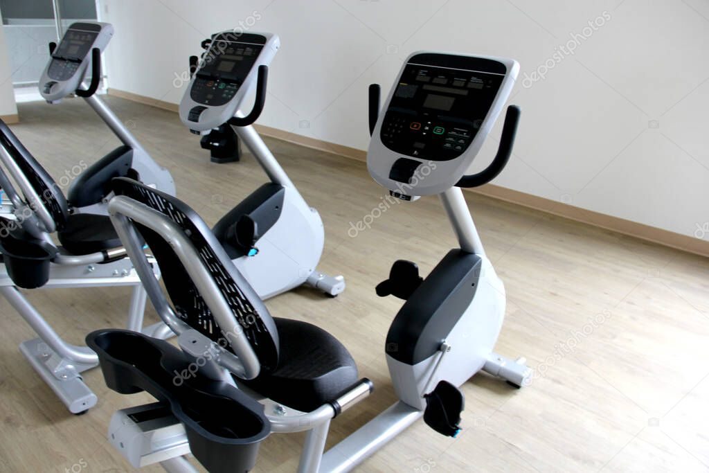 Black and white electric stationary recumbent bike in a gym for cardio, toning legs, burning calories and losing weight