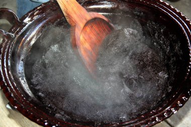 Kırmızı köstebeğin hazırlanması, kilden bir tencerede bulunan tipik bir Meksika yemeği. Ocağın üzerinde dev bir tahta kaşık ve tüm entegre bileşenler var.