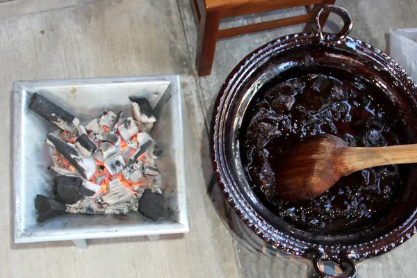 赤いモル すべての統合成分とストーブの火の上に巨大な木製のスプーンと粘土鍋で典型的なメキシコ料理の準備 — ストック写真