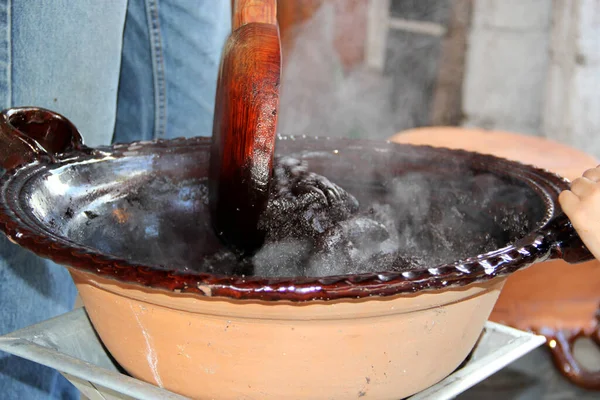 질그릇에 전형적 멕시코 요리로서 숟가락을 난로의 불위에 재료를 — 스톡 사진