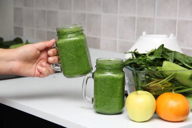 Sağlıklı ve besleyici bir kahvaltı için salatalık, pazı, ıspanak, limon ve meyve gibi sebzelerle servis edilen yeşil meyve suyu.