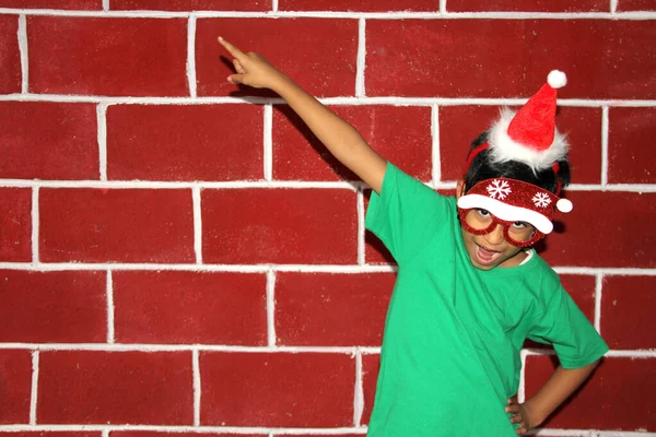 带着圣诞帽和圣诞眼镜的拉丁小男孩为12月的到来感到高兴和兴奋 圣诞节也展现了他的热情 — 图库照片