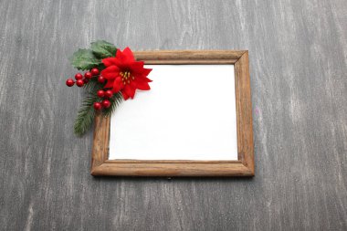 Fotoğraf çerçevesi Noel mesajı için Noel duası olarak çiçek, değnek ve çarkıfelek ile çevrili.