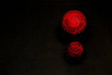 Siyah arkaplanda parlak kırmızı küreler Noel mesajı için dekoratif çerçeve olarak sevgi ve mutluluk
