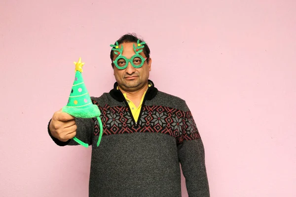 クリスマスの帽子と眼鏡を持つラテン系の大人の男は12月の到着時に彼の嫌悪と怒りを示しています 彼はクリスマスを祝うのが好きではありません — ストック写真