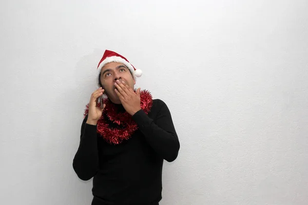 拿着圣诞帽 戴着红色花环的拉丁裔男子用手机给家人打电话 用愉快的视频呼叫 兴奋地庆祝圣诞节 — 图库照片
