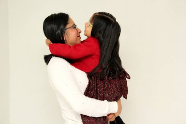 Latin anne ve kızı ailelerine çok mutlu, zarif ve sıradan bir şekilde Noel, Yeni Yıl, Thnaksgive, Aşk Günü, Anneler Günü gibi bayramları kutlamaya hazır olduklarını gösterirler.