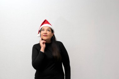 Şapkalı ve Noel çelenkli Latin yetişkin kadın Noel 'i ve yeni yılı kutlamak için heyecanını ve mutluluğunu gösteriyor.