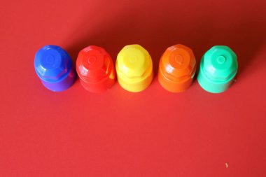Buildable colored plastic blocks to play, build and organize on a red background as a concept of inclusion, diversity and plurality