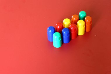 Buildable colored plastic blocks to play, build and organize on a red background as a concept of inclusion, diversity and plurality