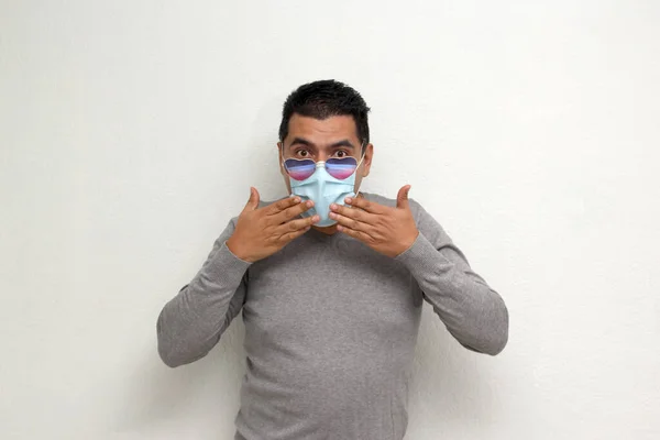 2月のバレンタインデーの愛と友情のために興奮顔のマスクとハート型のメガネを持つラテン成人男性Covid 19パンデミックのための新しい正常性 — ストック写真