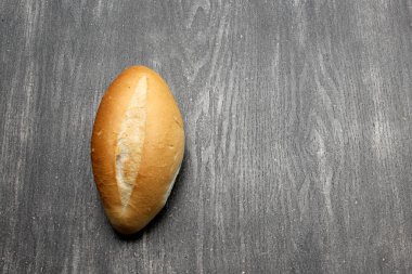 Taze, pofuduk, lezzetli, buğday unlu taze Meksika bolillo ekmeği, beyaz ekmek, somun veya Fransız ekmeği. Gri ahşap bir masada yemeye hazır.