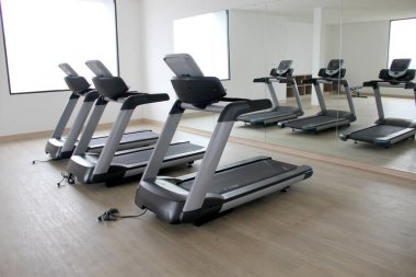 Yepyeni elektrikli koşu bantları, otelin veya apartmanın spor salonunda egzersiz aletleri kardiyo yaparak sağlıklı ve sağlıklı bir yaşam tarzı elde etmek için.
