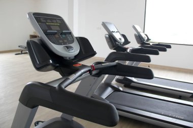 Yepyeni elektrikli koşu bantları, otelin veya apartmanın spor salonunda egzersiz aletleri kardiyo yaparak sağlıklı ve sağlıklı bir yaşam tarzı elde etmek için.