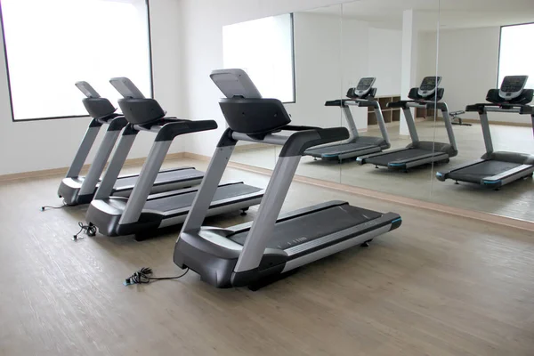 Yepyeni elektrikli koşu bantları, otelin veya apartmanın spor salonunda egzersiz aletleri kardiyo yaparak sağlıklı ve sağlıklı bir yaşam tarzı elde etmek için.