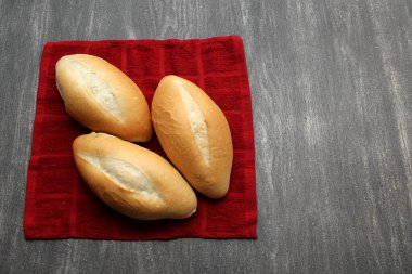 Taze, lezzetli, kabarık, çıtır çıtır, taze Meksika bolillo ekmeği, beyaz ekmek, somun ekmek ya da yemeye hazır gri ahşap bir masada peçete üzerinde Fransız ekmeği.