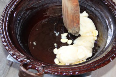 Geleneksel Meksika Köstebek Tabağı 'nın hazırlanmasında ilk adım. Malzemeler tereyağı ve sarımsak fırında pişirilmiş ve ahşap kaşıkla karıştırılmış..