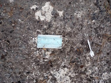 Küresel kirliliğin yeni bir formu olan Covid-19 salgını yüzünden çevreyi kirleten tıbbi atık olarak sokağa atılan üç katmanlı maskeler.