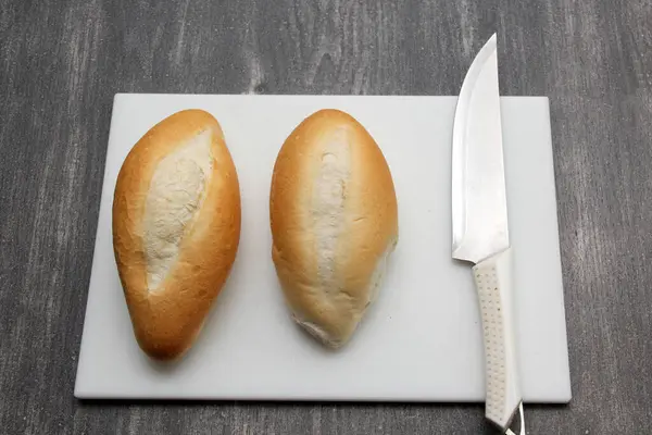 新鲜的墨西哥卷饼面包 法式面包 白面包在白板上 旁边是灰色桌子上的白刀 — 图库照片