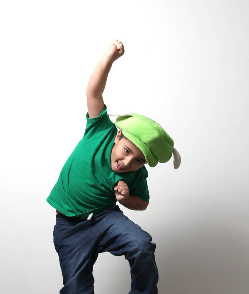 Латиноамериканец прыгает, как супер герой очень счастлив и взволнован наслаждается своими игрушками и шляпу, что они подарили ему на день рождения, Рождество или три короля день