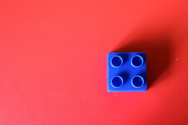 Οικοδομήσιμο Μπλε Πλαστικό Μπλοκ Κόκκινο Φόντο Έννοια Της Μοναξιάς Και — Φωτογραφία Αρχείου