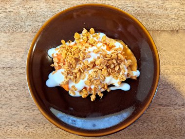 Sağlıklı ve sağlıklı kahvaltı için doğal yoğurt ve granola ile Papaya meyve tabağı şişman olmamak için sıkı bir diyetin bir parçası olarak kilo vermek için