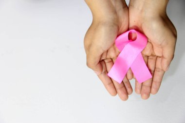 Göğüs kanserine karşı kampanya için beyaz arkaplanda kadın eli ve pembe kurdele