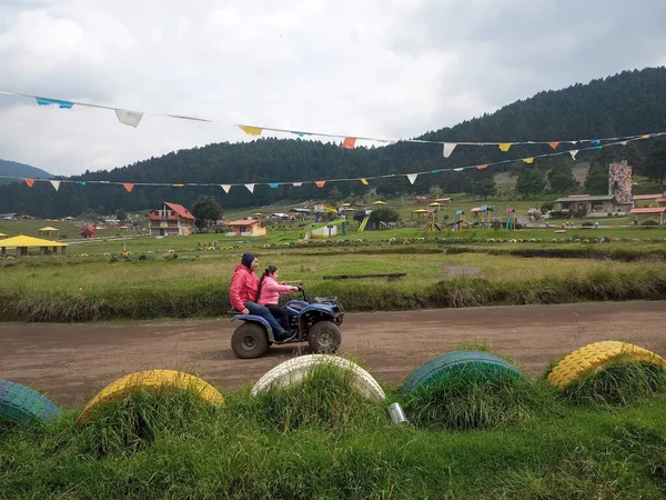 Latin bekar baba ve kızı, ormanın ortasında, ağaçlar ve doğa ile çevrili bir ATV 'de son sürat eğleniyorlar. Çok mutlu bir aile anı yaşıyorlar.