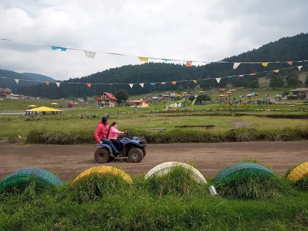 Latin bekar baba ve kızı, ormanın ortasında, ağaçlar ve doğa ile çevrili bir ATV 'de son sürat eğleniyorlar. Çok mutlu bir aile anı yaşıyorlar.