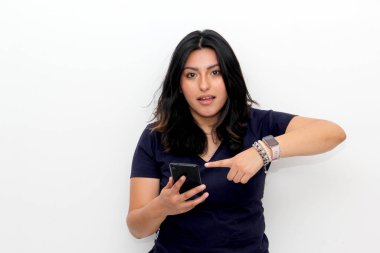 Akıllı telefonu işaret eden neşeli genç Latin kadın, beyaz bir arka planda online alışveriş uygulaması